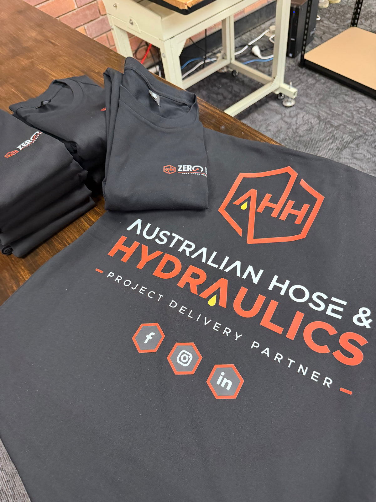 Real black business shirts printed by 60ft Ink for Australian Hose and Hydraulics, with chest and back logos.